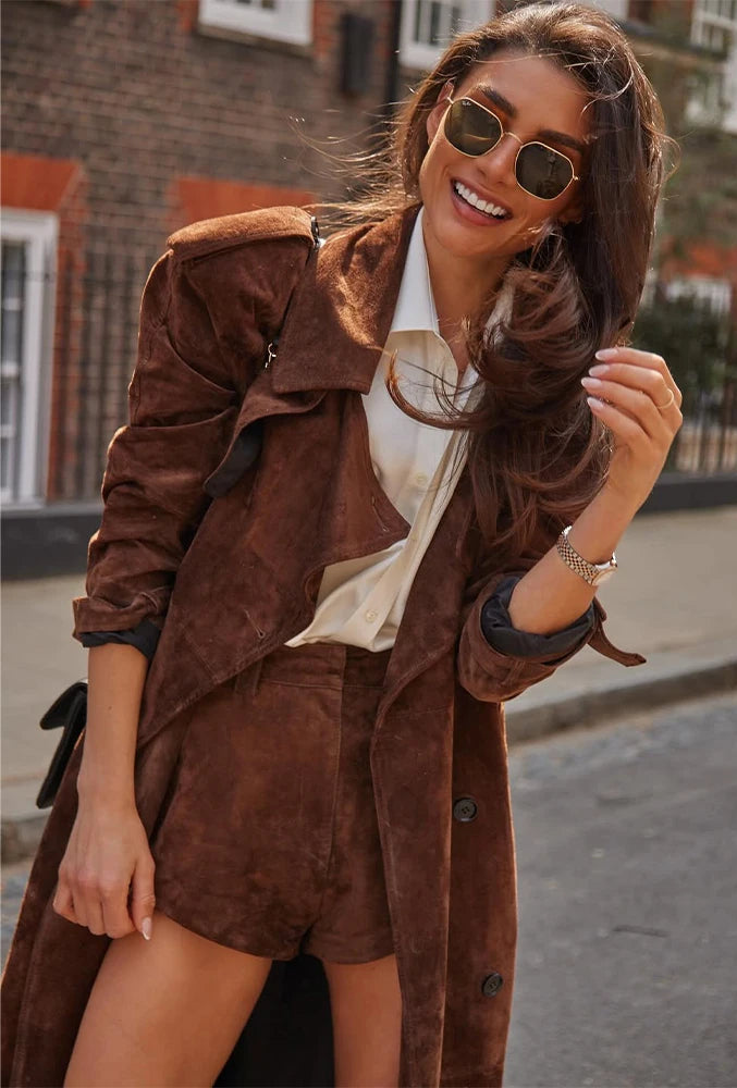 Woman wearing a brown suede outfit with sunglasses in an urban setting